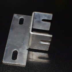 A metal mounting bracket with two slotted holes on the flat base and a U-shaped channel with slotted sides.
