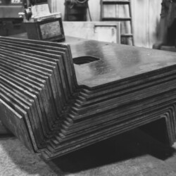 A stack of bent metal plates in a workshop.