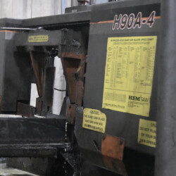 HEM Saw H90A-4 industrial band saw with yellow safety warning labels and a blade speed chart.